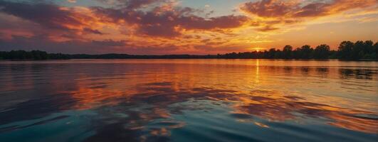 A beautiful sunset over a lake with clouds reflected in the water photo