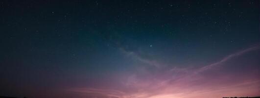 A purple sky with stars and clouds over a field photo