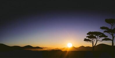 A silhouette of a tree and the sun setting over mountains photo
