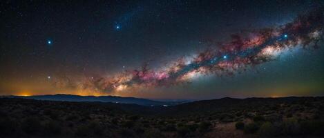 The milky way over the mountains in the night sky photo