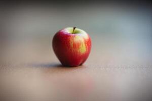 A single red apple on a table photo