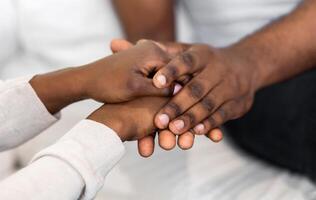 Closeup image of two hands holding each other, showing a sense of connection and support. photo