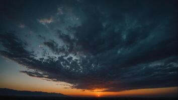 The sun sets behind a dark cloud over a field photo