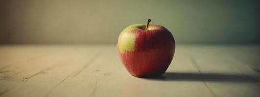 An apple sitting on a table with a blurry background photo