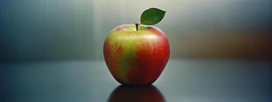 An apple is shown on a table with a blurred background photo
