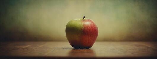 An apple sitting on a table in front of a green background photo