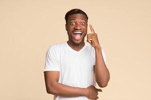 Idea. Excited African American Man Pointing Finger Up Coming Up With Problem Solution Standing On Yellow Studio Background. photo