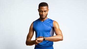 Time To Start. Portrait of black muscular man looking at smartwatch, checking fitness tracker, panorama, copyspace photo