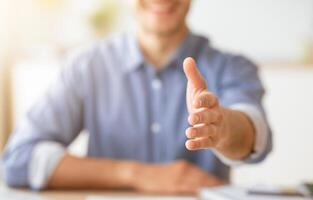 Handshake Gesture. Smiling Man Stretching Hand For Greeting Sitting At Home. Shallow Depth, Cropped photo