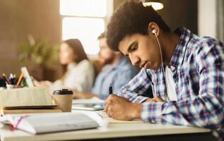 Black guy taking notes, preparing for classes in college library, studying together with classmates photo