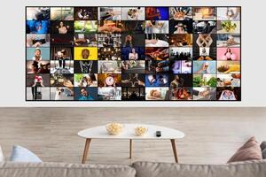 A collage of diverse images, each depicting a different scene and activity, is displayed on a television screen in a modern living room. The television screen is mounted on a white wall photo