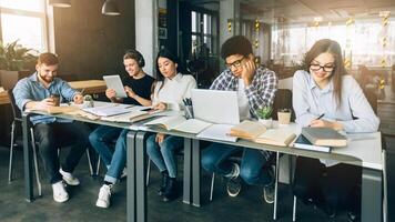 E-learning concept. Classmates studying in university library with gadgets, doing homework photo