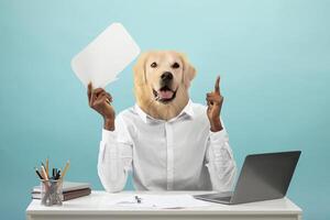 A person with the head of a golden retriever raises one hand while holding a blank speech bubble with their other hand. They are sitting at a desk with a laptop and stationery photo