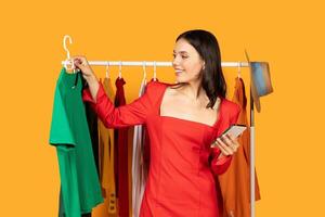 A woman is standing in front of a clothing rack, browsing through the different items. She appears focused and intent on finding something that catches her eye. photo