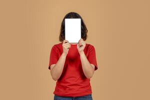 This image shows a woman in a red shirt holding a tablet in front of her face. The tablet has a white screen, which is perfect for displaying your message or design photo