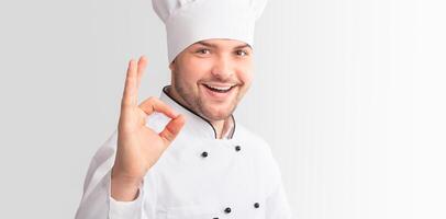 Confident Chef Man Gesturing Okay Sign Approving Recipe Standing On White Studio Background. Panorama photo