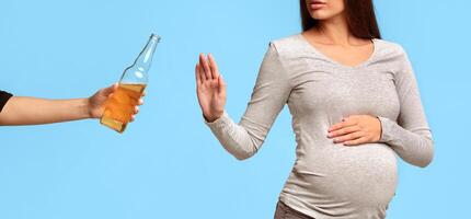 Unrecognizable Pregnant Girl Gesturing Stop To Beer Bottle Standing On Gray Studio Background. Panorama, Cropped photo