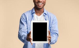 Great Application. Smiling Black Guy Showing Blank Tablet Computer Screen Posing On Yellow Studio Background. Mockup, Cropped photo