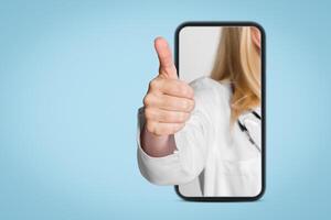 A doctors hand emerges from a smartphone screen, giving a thumbs up gesture. This image is a representation of modern healthcare and the use of technology for communication and patient care. photo