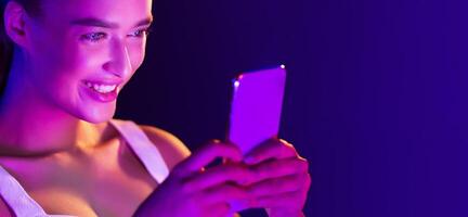 A woman is happily smiling while using a cell phone to communicate with someone. She is engaged in the conversation and appears content, panorama with copy space photo