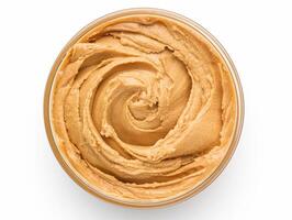 Bowl of peanut butter isolated on white background, top view photo