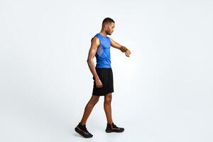 Time Limit. Full length black sports man using fitness tracker over yellow studio background, copyspace photo