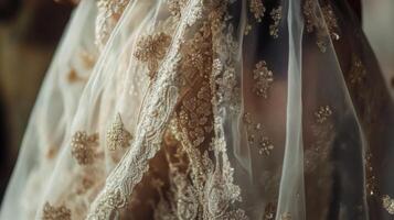 A close-up view of a wedding dress highlighting delicate lace and beading, with soft lighting enhancing the intricate details. photo