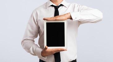 Business App. Cheerful Guy Showing Blank Tablet Computer Screen On White Background In Studio. Mockup photo