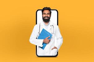 A young indian man doctor stands inside the screen of a smartphone, symbolizing a virtual consultation, set in a modern, light-filled clinic. photo