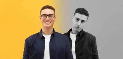 One man stands cheerfully smiling while the other displays a serious expression, creating a striking contrast. They are positioned against a vivid yellow and muted gray backdrop photo