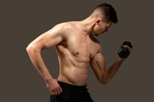 A man is holding a dumbbell in his hands, showcasing strength and fitness training. Mans muscles are visibly engaged as he lifts the weight, demonstrating dedication to physical exercise and health. photo