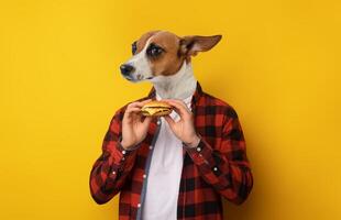 A person with a dog's head is wearing a red and black flannel shirt and is holding a burger in their hands. The person is looking to the left of the camera. The background is a solid yellow color. photo