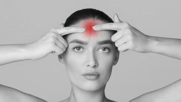 A woman with a noticeable red spot on her head. She appears to be standing in a room with a serious expression on her face. photo