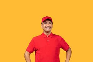 A cheerful man stands with his hands on his hips, wearing a bright red uniform and matching cap, against a vibrant yellow backdrop. He is smiling widely, appearing enthusiastic and approachable. photo