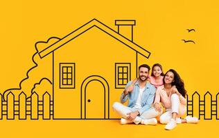 A happy family, consisting of a father, mother, and daughter, are seated close together in casual attire against a vivid yellow backdrop featuring a hand-drawn illustration of a house photo