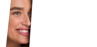 The image shows a woman face peeking through a perfectly circular hole in a white piece of paper. Her features are visible, framed by the edges of the hole. photo