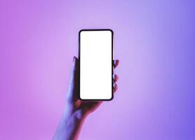 Hand holds smartphone with blank screen in neon, free space photo