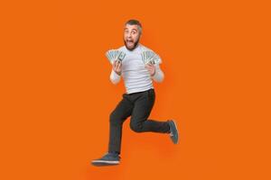 A man is seen running with a handful of money in his grasp. He appears to be in a rush, his focus solely on the fast-paced action of running while clutching the cash tightly. photo