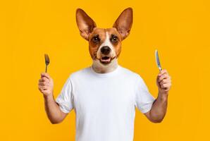 A cheerful dog character with human-like features stands holding a fork in one hand and a knife in the other. The bright yellow backdrop enhances the playful atmosphere photo