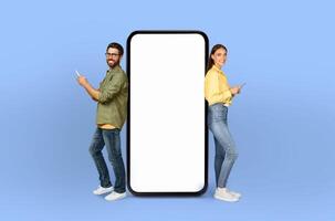 The smartphone between them, with its screen unmarked, complements the vibrant energy and diverse backgrounds of the smiling young lovers photo