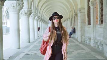 Confident woman walks on palace gallery with large columns video