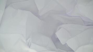 Sheet of white crumpled paper on black table in dark studio video