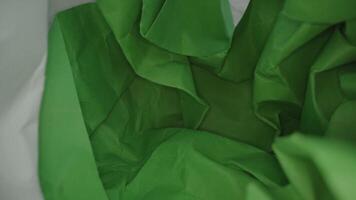 Motion through crumpled paper sheets in light studio video
