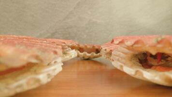 Scarlet-colored mollusks open thin shells lying on table video