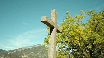 Lithic cross monument against mountains and trees in park video