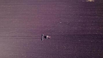 Shooting from drone flying over tractor with harrow system video