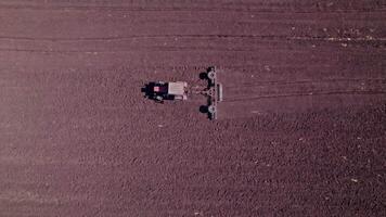 Tractor tilling center of farm field in the fall video