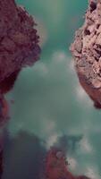 A stunning rock formation surrounded by water from a bird's-eye view video