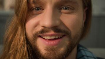 Close up Caucasian bearded man male guy sleeping napping relaxing leaning couch sofa wake up looking at camera smiling happy laughing smile positive face portrait laugh satisfied indoors joy fun funny video