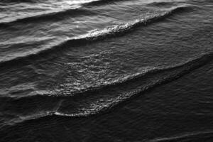 Black and white photograph of waves on the beach photo